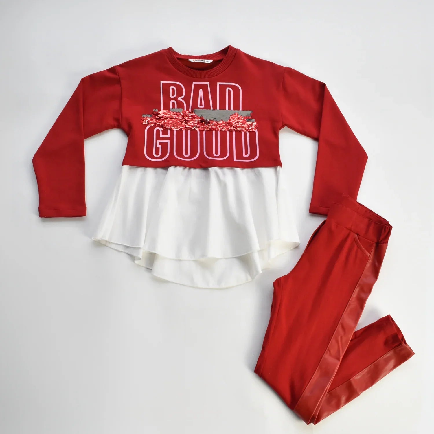 Undecided Love Girls Casual Set featuring a red top with layered pleats and red pants with leather accents.