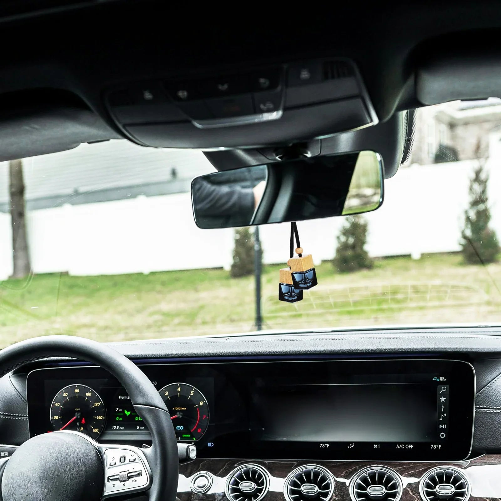 Hanging car perfume diffuser in an elegant car interior, enhancing ambiance and freshness.