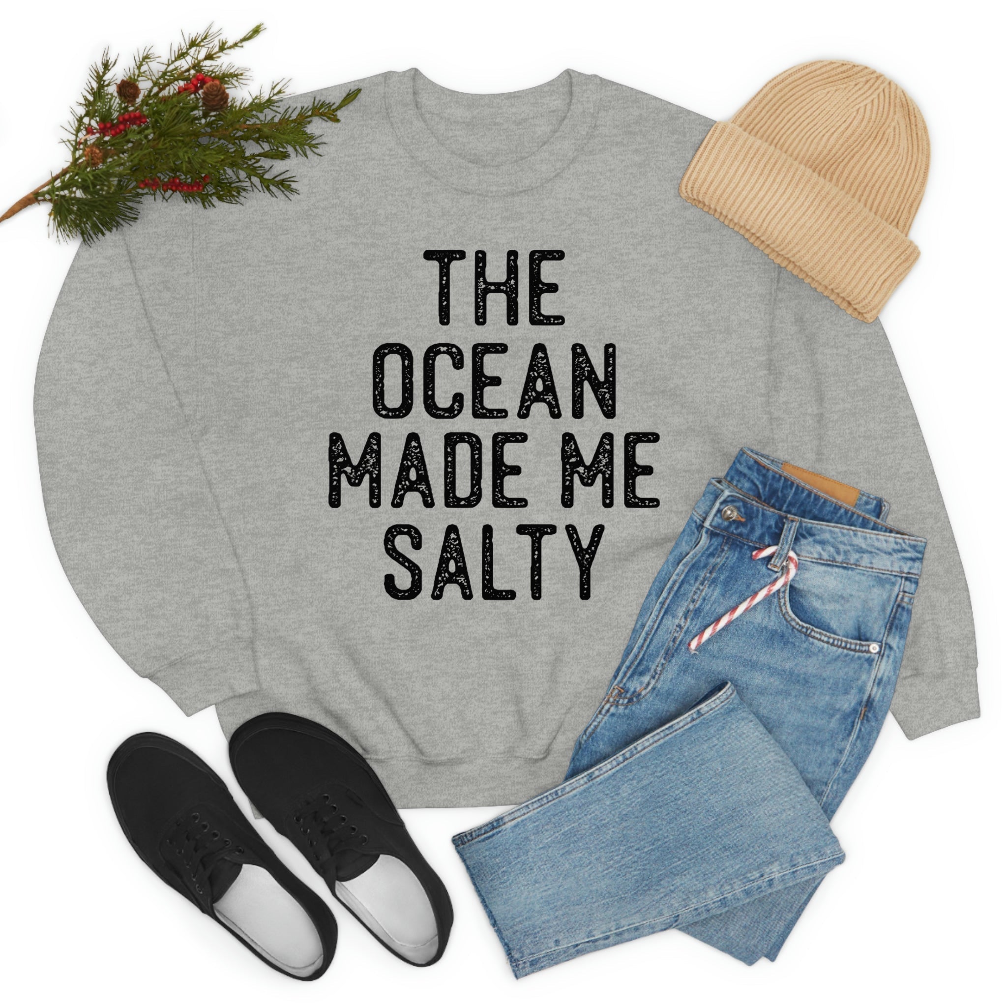 The Ocean Made Me Salty sweatshirt displayed with jeans, sneakers, and a knit hat, showcasing stylish casual wear.