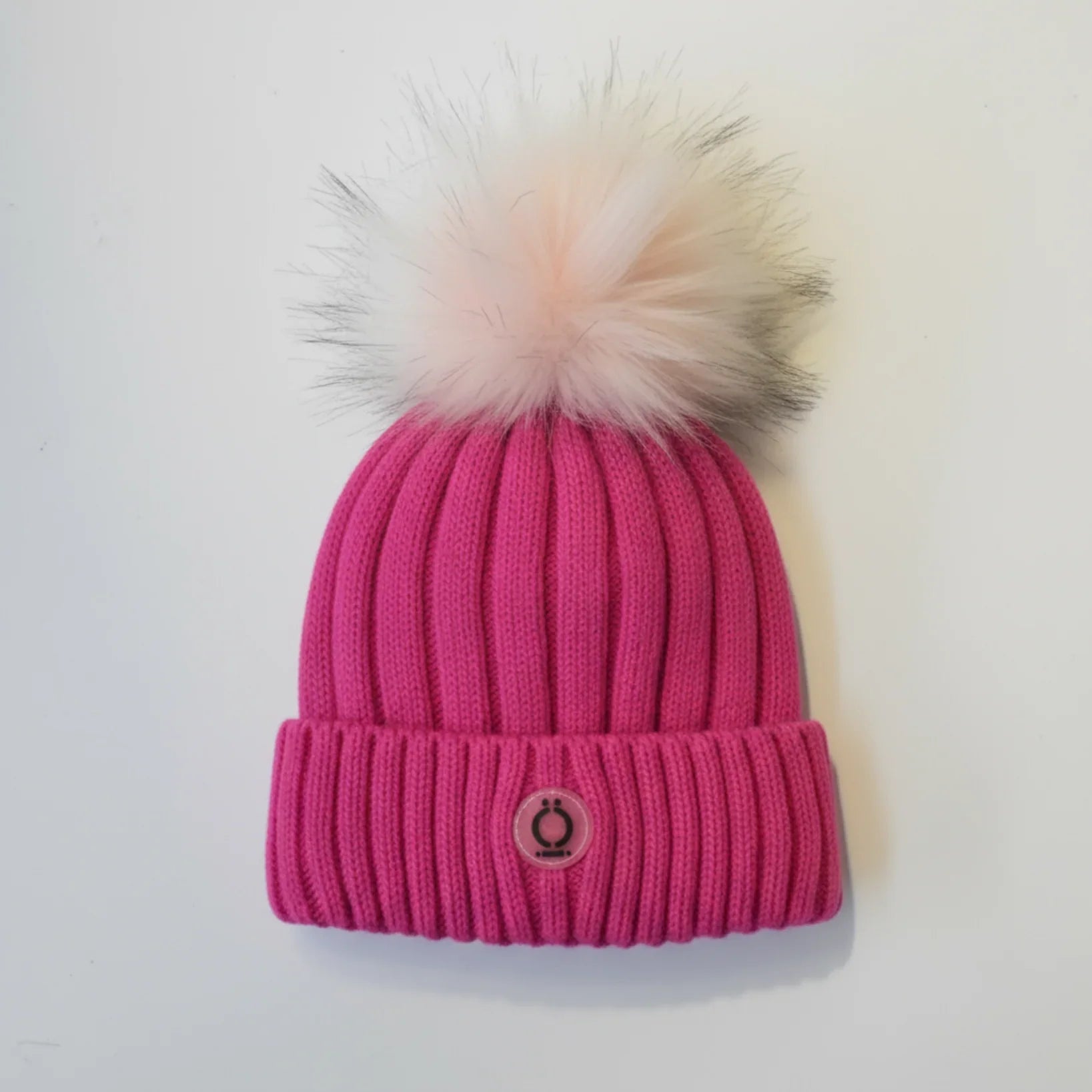 Fushia Tuque featuring soft fur pompom and polar fleece lining, perfect for stylish warmth.