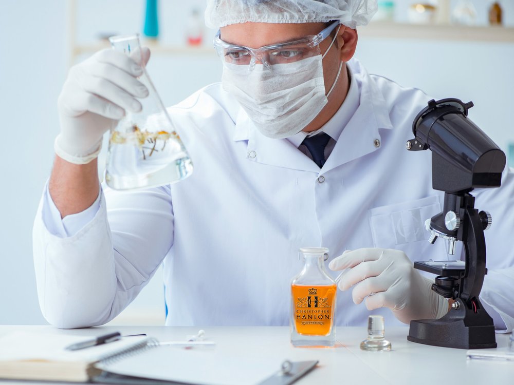 Scientist examining fragrance ingredients in a lab for The DELUXE PERFUME COLLECTION (Pick 5). Get *FREE Cashback.