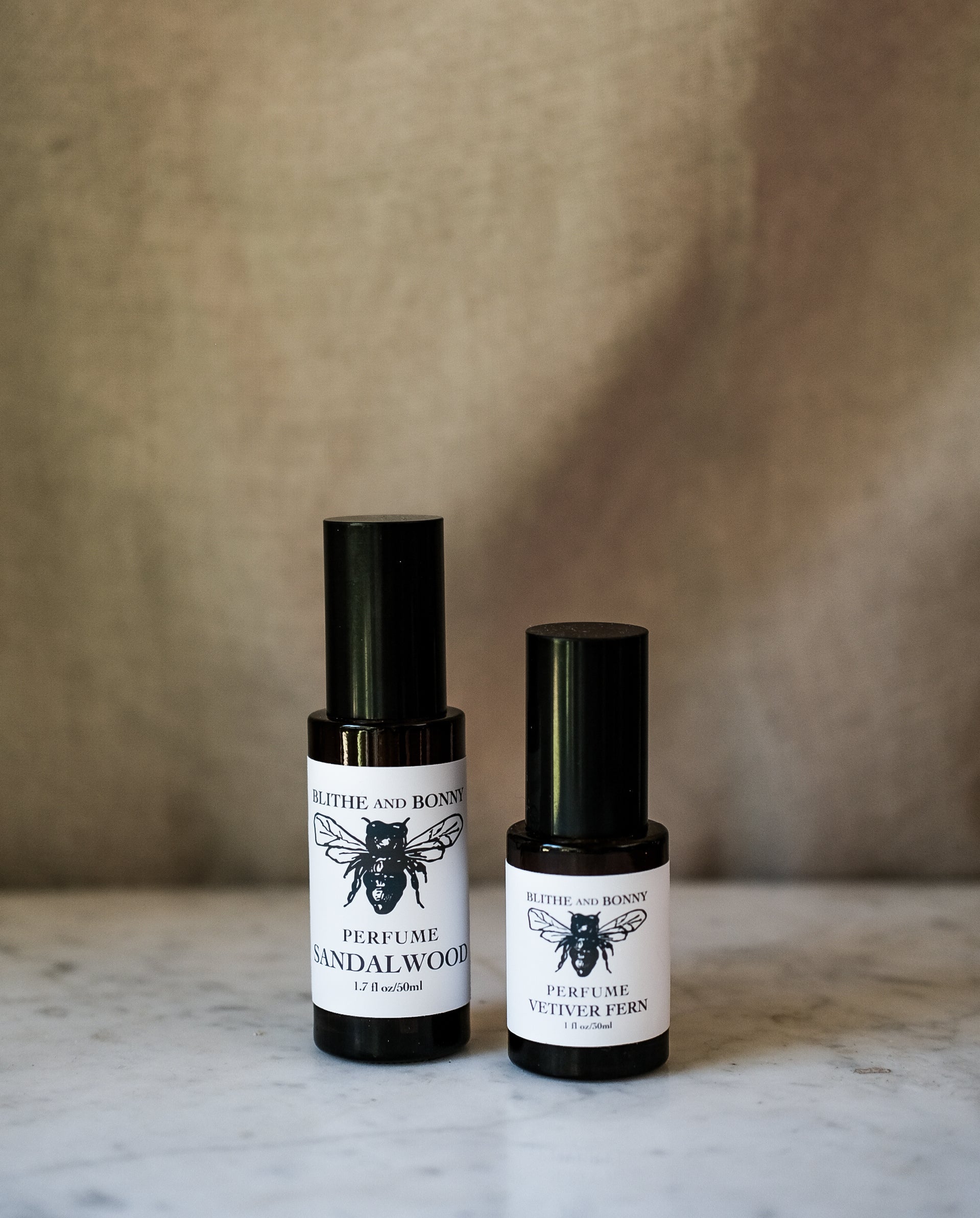 Grand Perfume collection featuring sandalwood and vetiver fern in sleek black glass bottles.