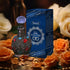 NNETM Enchanted Arabian Dreams Essential Oil Perfume bottle with ornate design and blue packaging surrounded by roses.