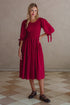 Freya Smocked Linen Midi Dress featuring a smocked bodice and tie up puff sleeves in a rich red color.