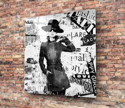 Fashion Glass Wall Art featuring a stylish woman in a chic outfit against a collage of fashion-related text.