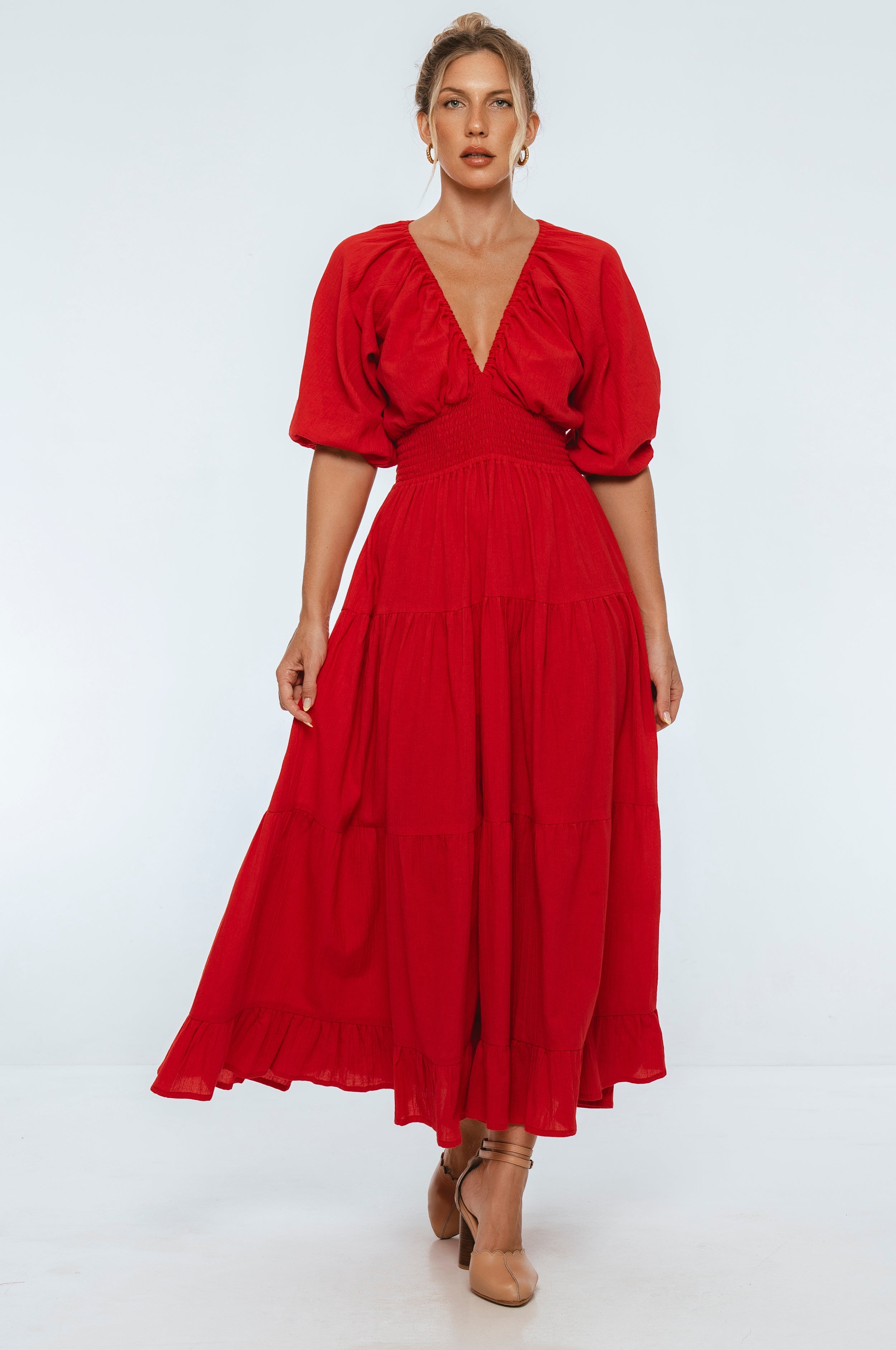 Lucienne Smocked Linen Maxi Dress worn by a model with voluminous puff sleeves and a deep V neckline.