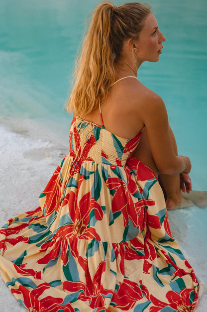 Sea Dreamer Strappy Midi Dress featuring vibrant floral design and a flowing two-tier skirt by the beach.