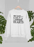 My Class Is Full Of Sweet Hearts Sweat Shirt displayed on a hanger with tropical leaves in the background.