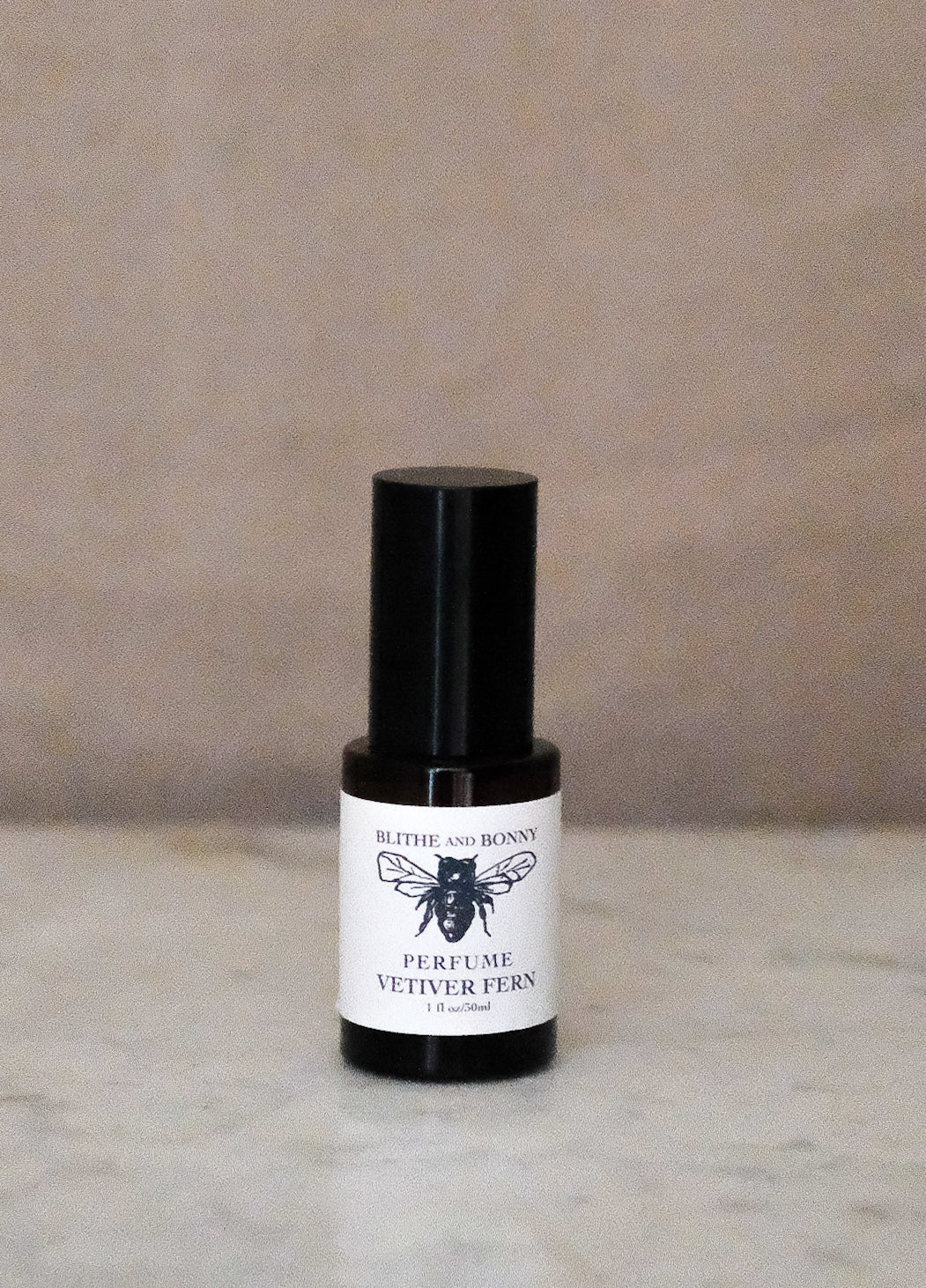 Petite Perfume Vetiver Fern 1.1oz bottle on marble surface with black spray top and simple label design.
