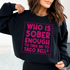 Woman wearing black sweatshirt with pink text: WHO IS SOBER ENOUGH TO TAKE ME TO TACO BELL?